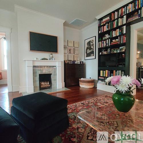 sitting room with a tile fireplace, ornamental molding, wood-type flooring, and built in features