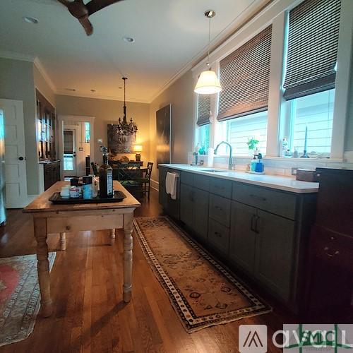 kitchen featuring crown molding, sink, decorative light fixtures, and hardwood / wood-style floors