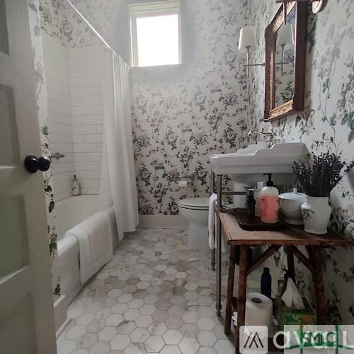 bathroom with shower / tub combo with curtain and toilet