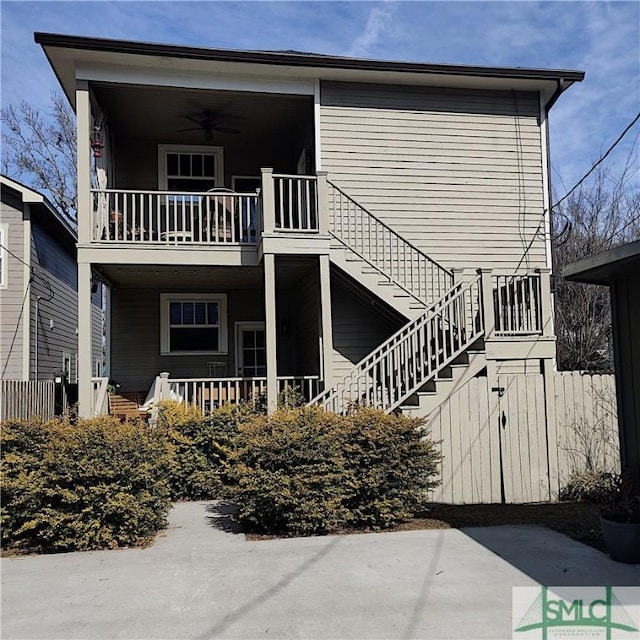 back of house with ceiling fan and a balcony