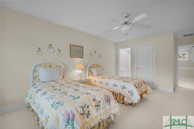 carpeted bedroom featuring ceiling fan and ensuite bath