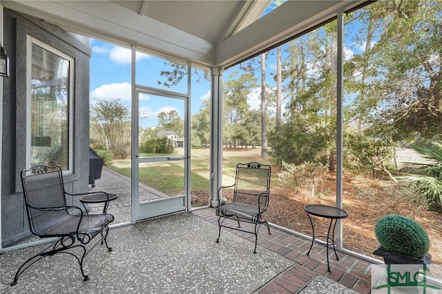 sunroom featuring lofted ceiling and plenty of natural light