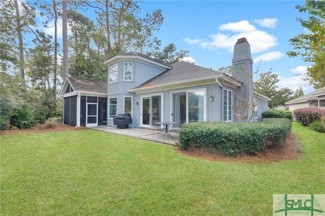 rear view of property featuring a sunroom, a patio area, and a lawn