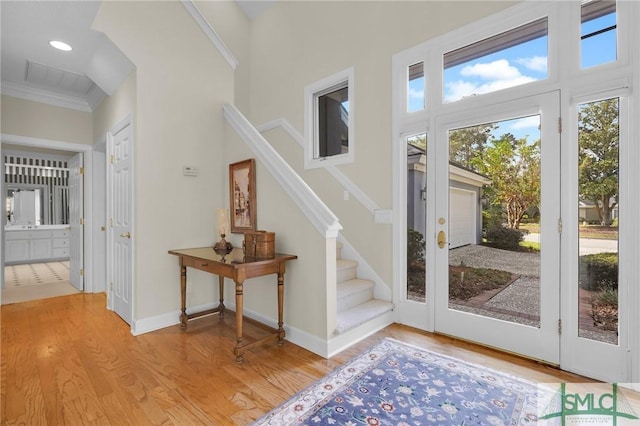 doorway to outside featuring crown molding and light hardwood / wood-style flooring