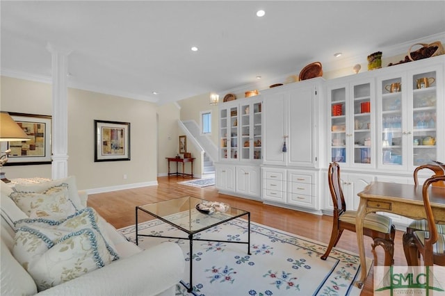 living room with crown molding and light hardwood / wood-style floors