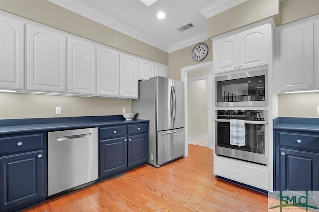 kitchen with stainless steel appliances, white cabinets, and blue cabinetry