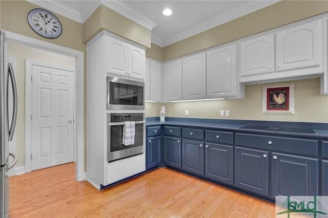 kitchen with blue cabinets, white cabinets, stainless steel appliances, crown molding, and light hardwood / wood-style flooring