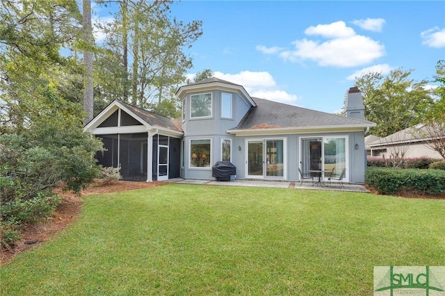 rear view of property with a patio, a sunroom, and a lawn