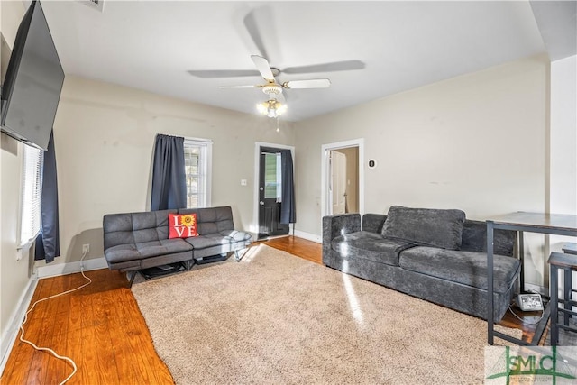 living room featuring hardwood / wood-style floors and ceiling fan