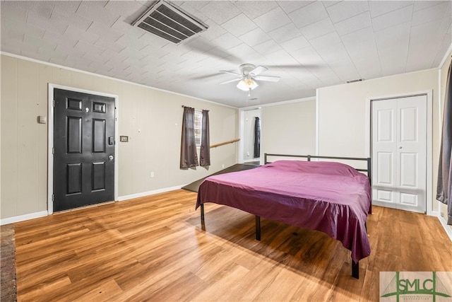 bedroom with ornamental molding, ceiling fan, and light hardwood / wood-style floors