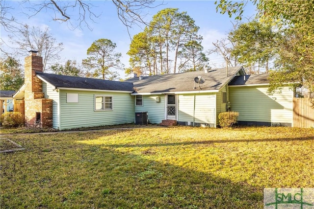 back of property featuring cooling unit and a lawn