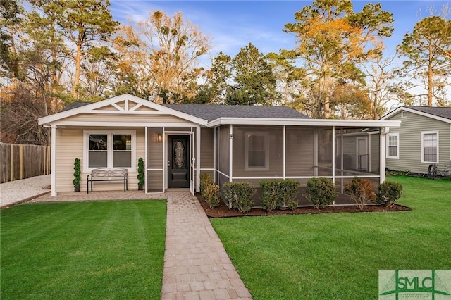 view of front facade with a sunroom and a front lawn