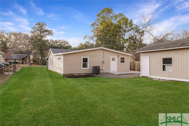 back of property featuring cooling unit, a lawn, an outdoor structure, and a patio area