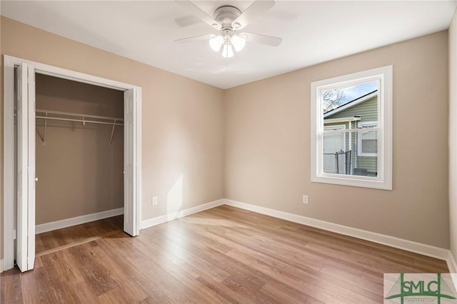 unfurnished bedroom featuring hardwood / wood-style flooring, a closet, and ceiling fan