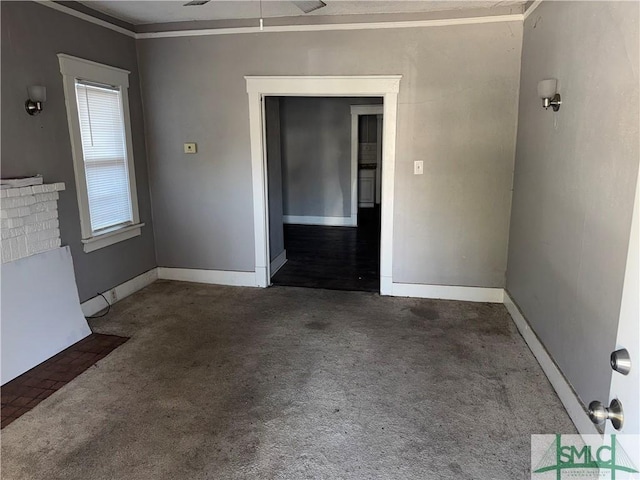 unfurnished room with crown molding, a fireplace, and dark colored carpet