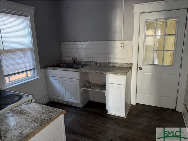 kitchen with tasteful backsplash, white cabinetry, sink, and dark hardwood / wood-style flooring