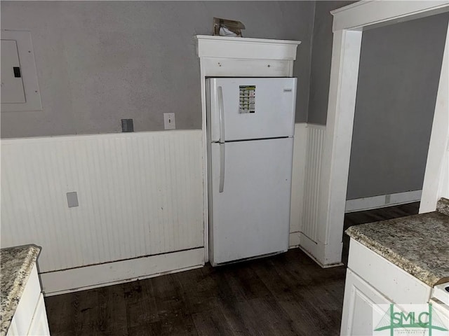 kitchen with white refrigerator, electric panel, dark wood-type flooring, and white cabinets