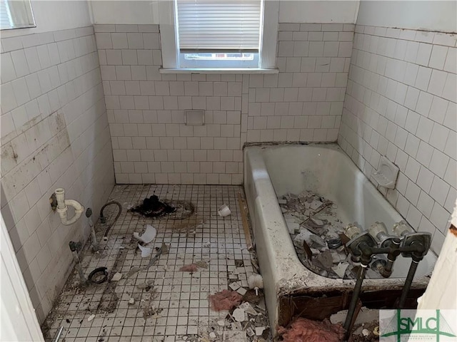 bathroom with tile patterned flooring, tile walls, and a washtub