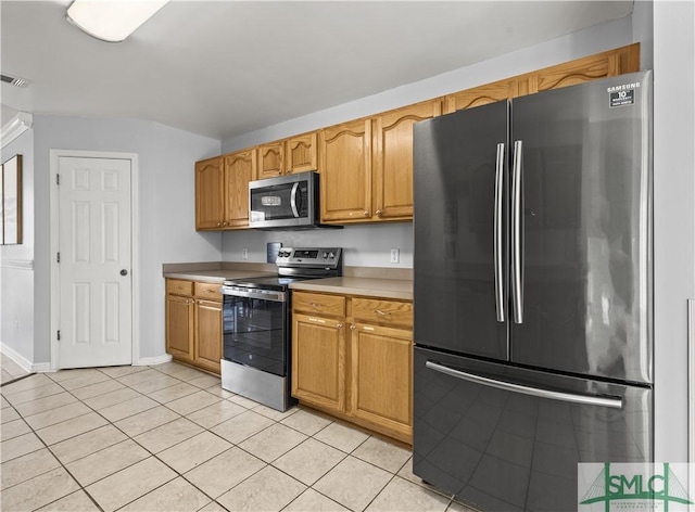 kitchen with light tile patterned flooring and appliances with stainless steel finishes