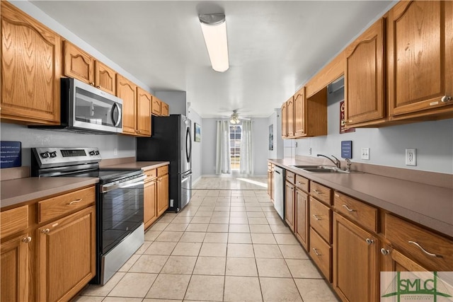 kitchen featuring stainless steel appliances, sink, light tile patterned floors, and ceiling fan