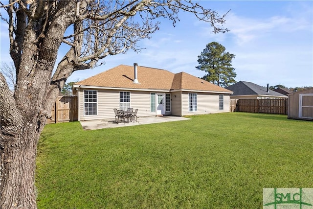 back of house featuring a storage unit, a patio, and a lawn