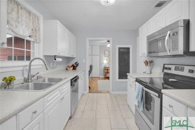 kitchen with ceiling fan, stainless steel appliances, sink, and white cabinets