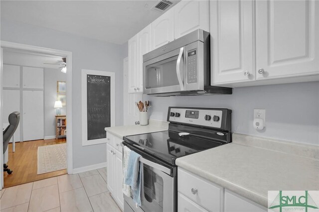 kitchen featuring white cabinetry, appliances with stainless steel finishes, light tile patterned flooring, and ceiling fan