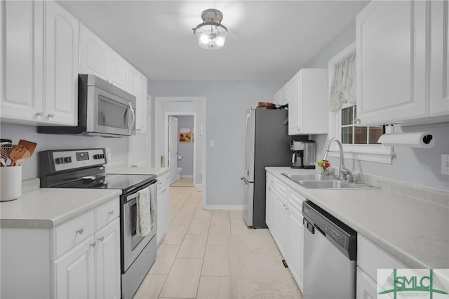 kitchen with stainless steel appliances, white cabinetry, and sink