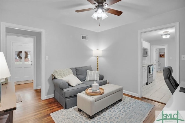 living room featuring ceiling fan and light wood-type flooring