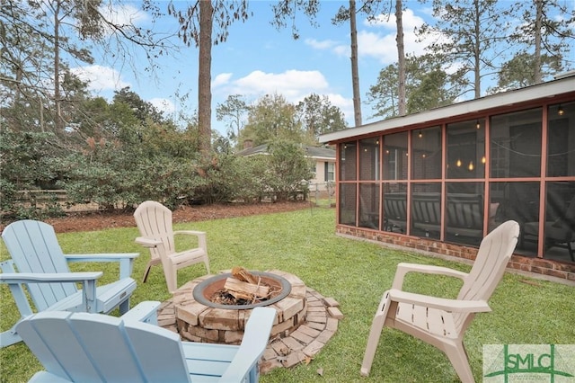 view of yard with a sunroom and a fire pit