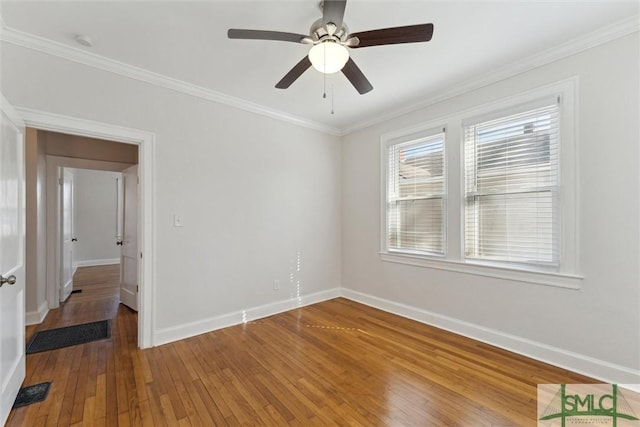 spare room with hardwood / wood-style flooring, crown molding, and ceiling fan