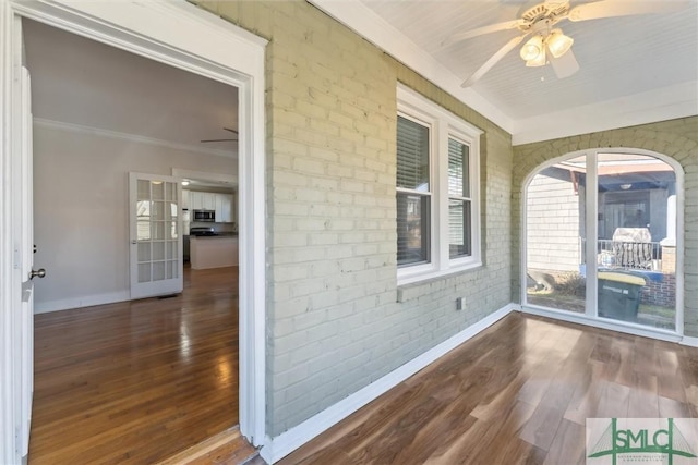 unfurnished sunroom featuring ceiling fan