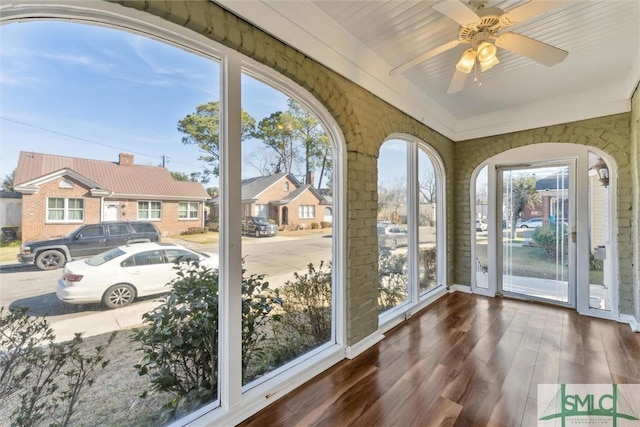 unfurnished sunroom featuring ceiling fan