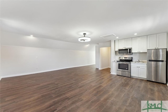 kitchen featuring white cabinetry, appliances with stainless steel finishes, dark hardwood / wood-style floors, and sink