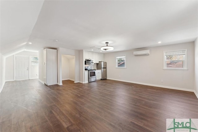 unfurnished living room with dark wood-type flooring, a wall mounted AC, and vaulted ceiling