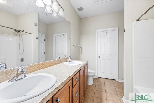 bathroom featuring vanity, a textured ceiling, tile patterned floors, and toilet