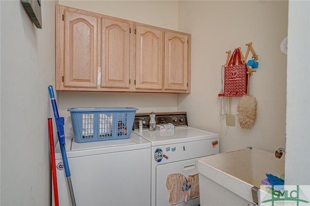 clothes washing area featuring cabinets, sink, and washing machine and dryer