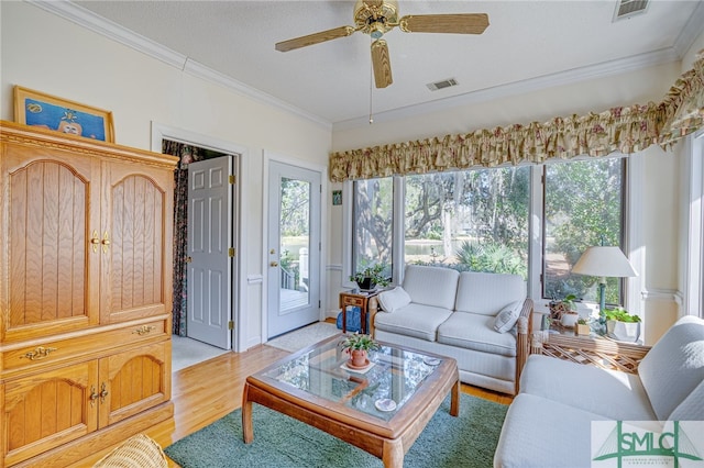 living room with crown molding, light hardwood / wood-style flooring, and ceiling fan