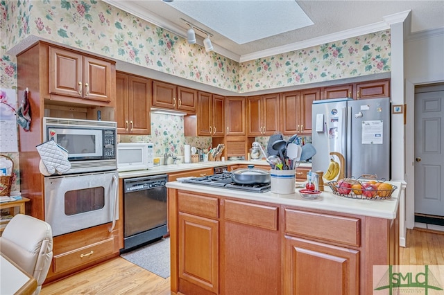 kitchen with a kitchen island, crown molding, appliances with stainless steel finishes, and light wood-type flooring