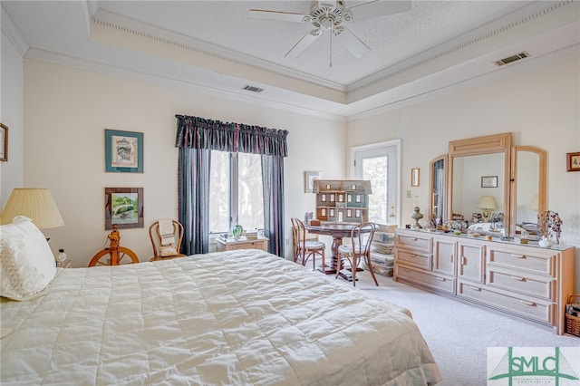 carpeted bedroom featuring a raised ceiling, ornamental molding, and a textured ceiling