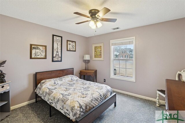 carpeted bedroom featuring ceiling fan and a textured ceiling