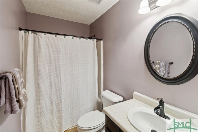 bathroom featuring vanity, a textured ceiling, toilet, and walk in shower