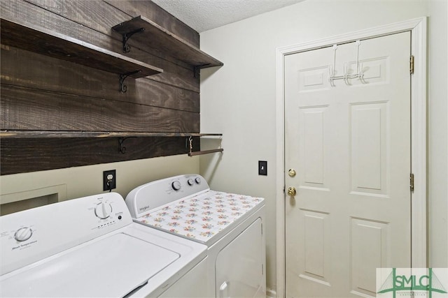 clothes washing area featuring washing machine and clothes dryer and a textured ceiling