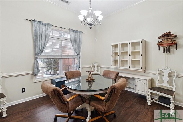 dining room featuring dark hardwood / wood-style flooring, crown molding, and a chandelier