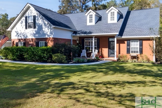 cape cod-style house with covered porch and a front yard