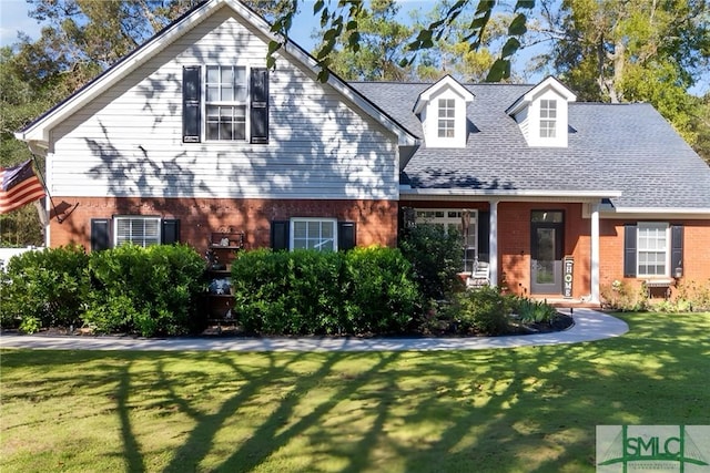 cape cod home featuring a front lawn