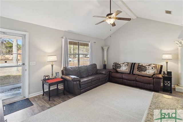 living room featuring ceiling fan, a healthy amount of sunlight, dark wood-type flooring, and vaulted ceiling with beams