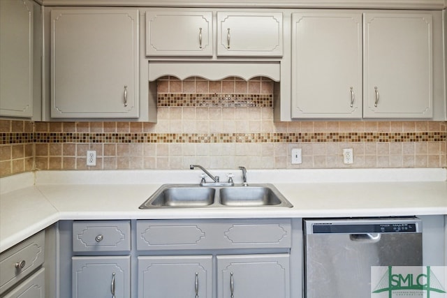 kitchen with gray cabinets, tasteful backsplash, sink, and stainless steel dishwasher