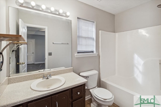 full bathroom with washtub / shower combination, vanity, toilet, and a textured ceiling