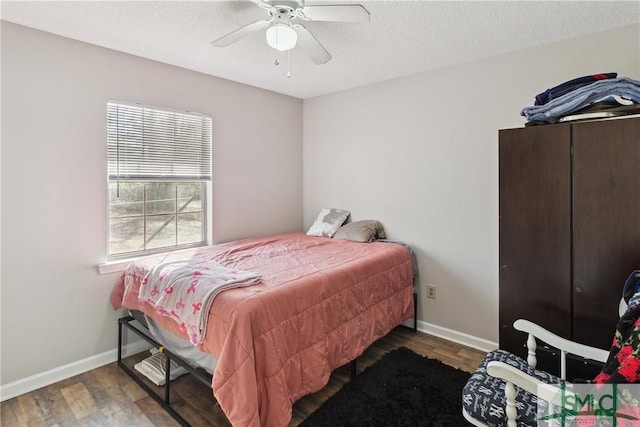 bedroom featuring ceiling fan, dark hardwood / wood-style flooring, and a textured ceiling